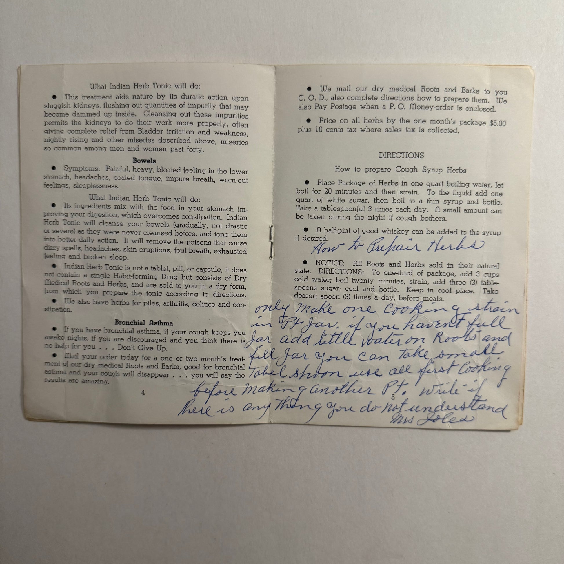 Open book with printed text and handwritten notes on a gray background