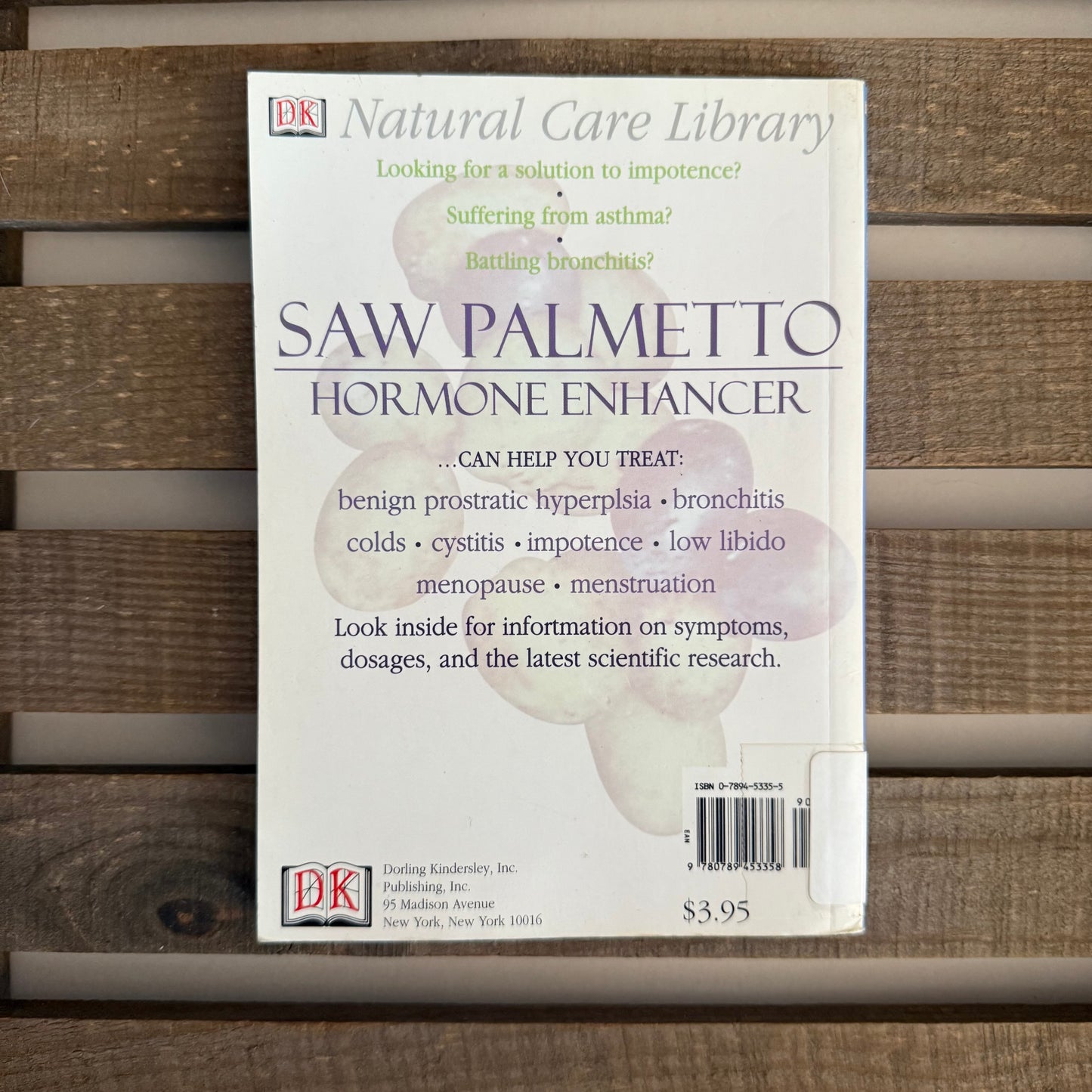 Book titled 'Saw Palmetto Hormone Enhancer' from the Natural Care Library on a wooden surface.