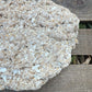 Close-up of a textured stone surface with wooden background