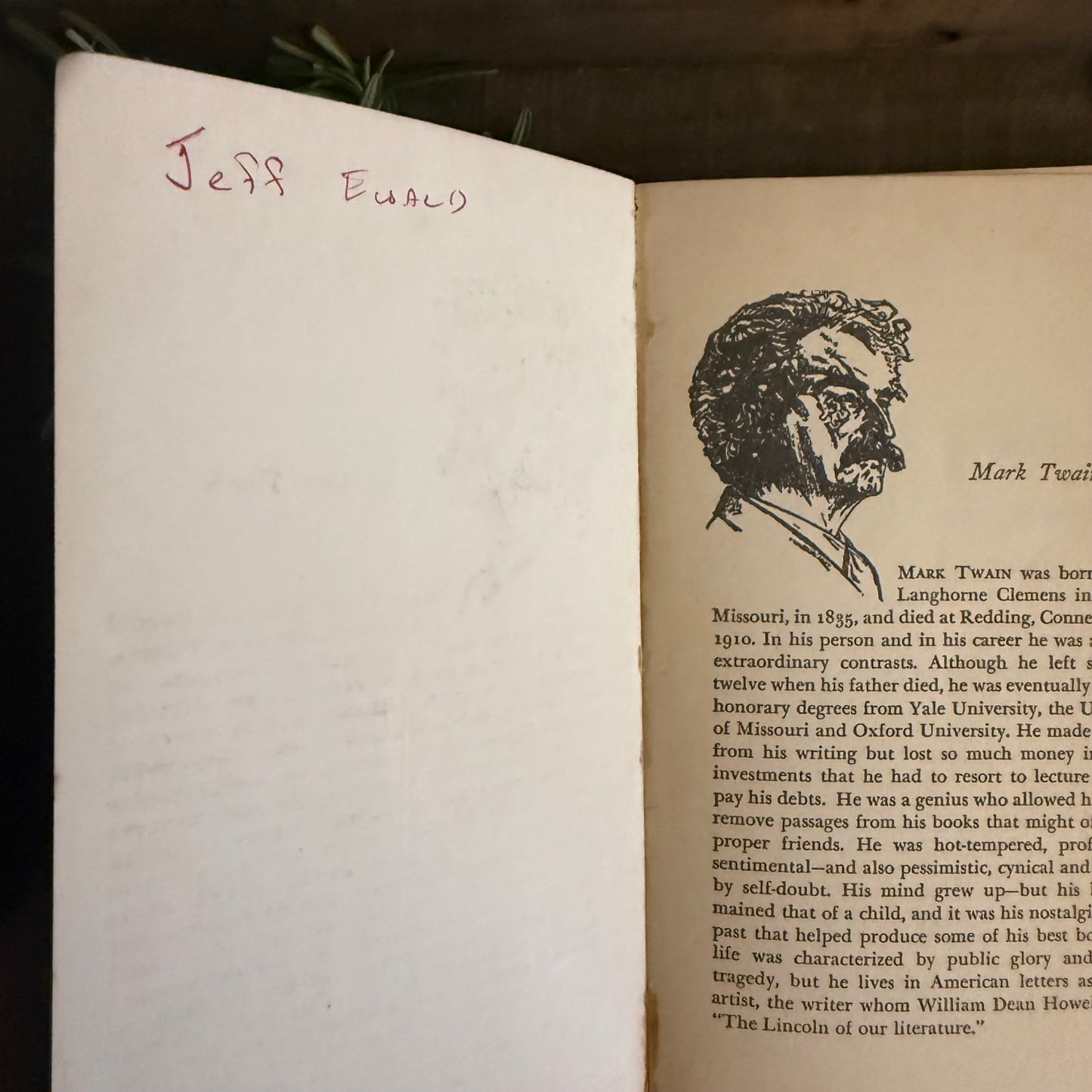 Open book with a portrait of Mark Twain and handwritten name 'Jeff Ewald' on a wooden surface.